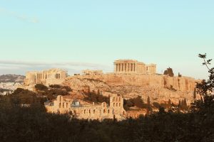 The iconic Acropolis of Athens, a UNESCO World Heritage Site, bathed in warm sunset light.