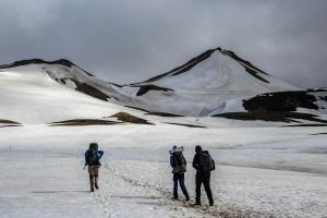 Three hikers traverse snowy peaks in Iceland, capturing the essence of adventure and winter exploration.