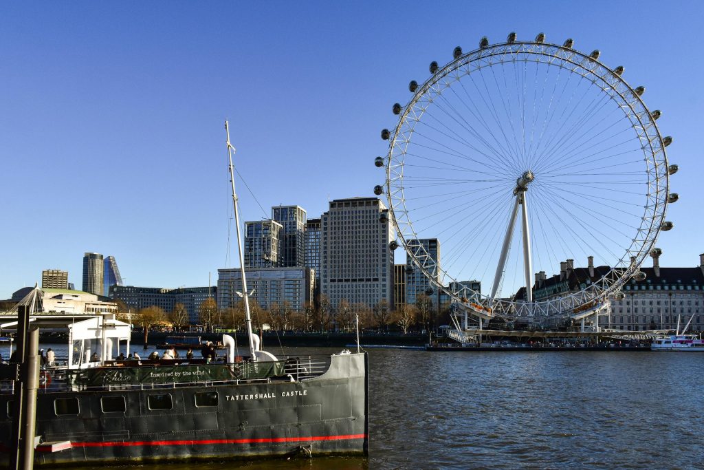 Vibrant daytime view of the London Eye and River Thames, capturing urban London life.