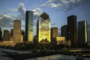 View of Houston's downtown skyline with a beautiful sunset reflection on skyscrapers.