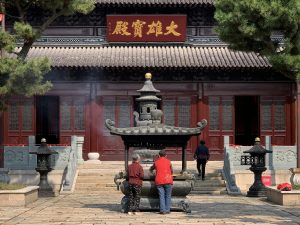 Visitors engage in quiet reflection at a traditional Chinese temple in Tai Zhou Shi, China.
