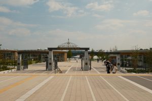 Visitors exploring the entrance of Expo 2005 Aichi Commemorative Park in summer.