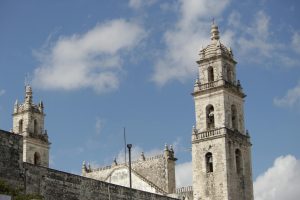 A scenic view of the historic cathedral towers against a clear blue sky in Merida, Mexico.