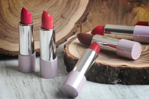 A stunning collection of colorful lipsticks resting on a rustic wood background, perfect for beauty and fashion themes.