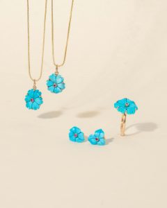 Chic blue flower-themed jewelry set featuring gold chains and rings, perfect for stylish accessorizing.