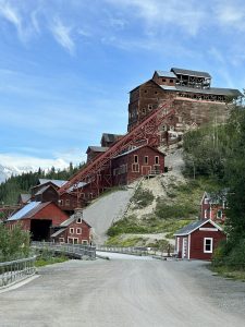 Red wooden buildings of Kennecott Mine against a clear blue sky in Alaska.