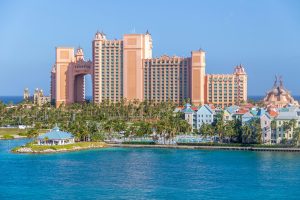 Scenic view of the Atlantis Resort amidst palm trees and blue ocean, Nassau, Bahamas.