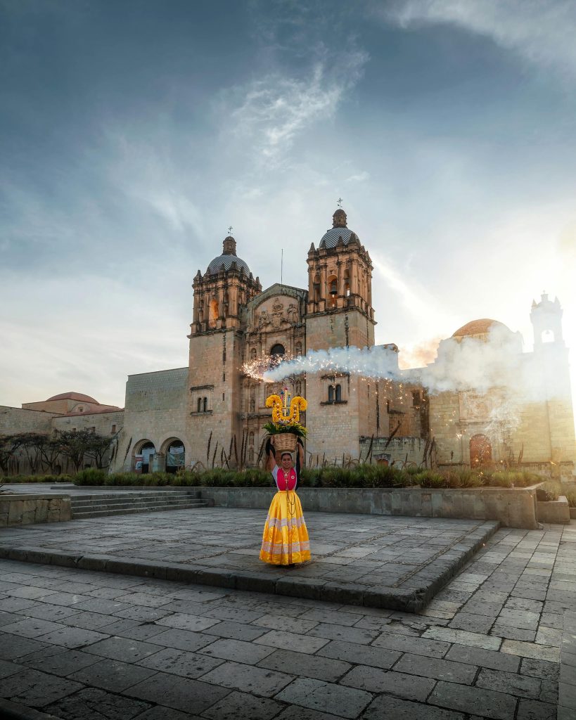 Woman in traditional attire dances at Santo Domingo Church in Oaxaca, Mexico.